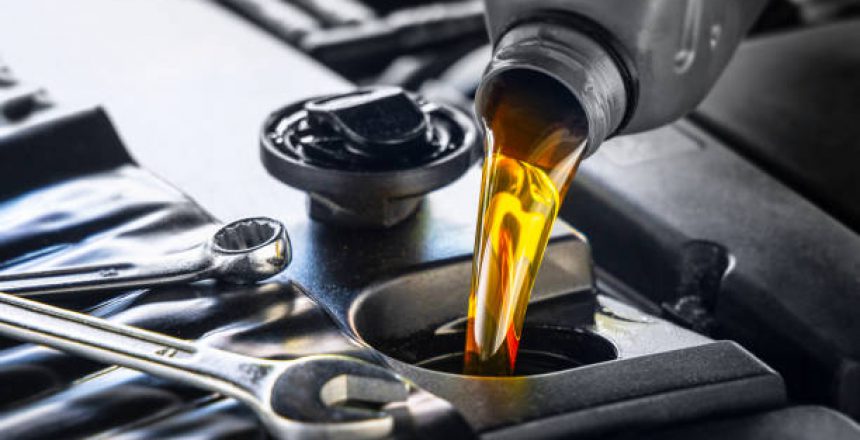 Pouring motor oil for motor vehicles from a gray bottle into the engine, ,  oil change,  auto repair shop, service,
